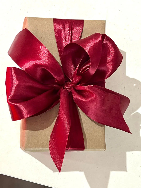 Hand-wrapped Christmas gifts with red ribbon