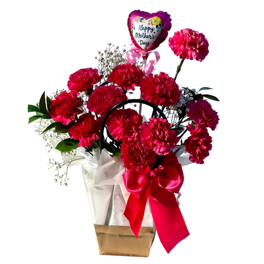 A bouquet of red carnations arranged beautifully in a paper wrap with a red ribbon, placed next to a 'Happy Mother's Day' balloon.