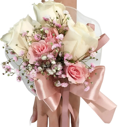 Floral corsage with pink and white flowers and ribbons on a white background