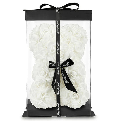 White rose bear in a clear packaging with black ribbon and tag on a white background
